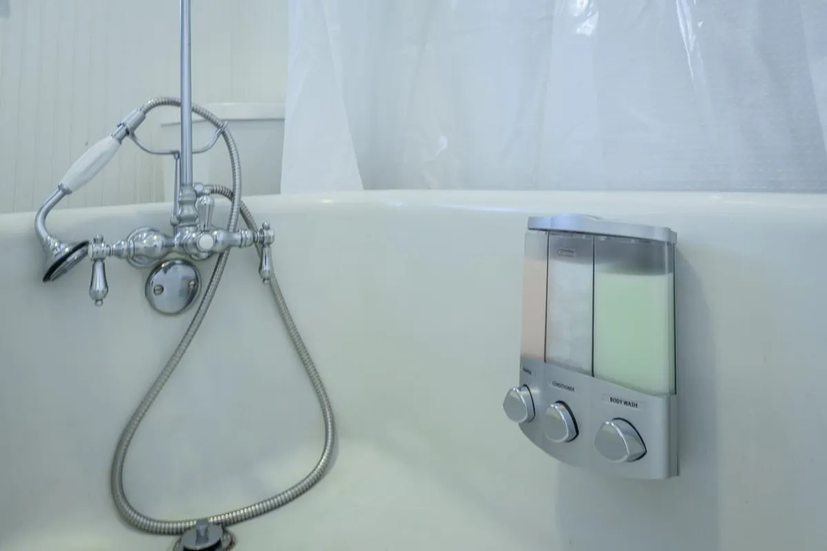 A modern bathroom featuring a pristine bathtub, elegant showerhead, and stylish soap dispenser. The space feels serene and spa-like, perfect for unwinding and enjoying a refreshing shower or a luxurious bath.